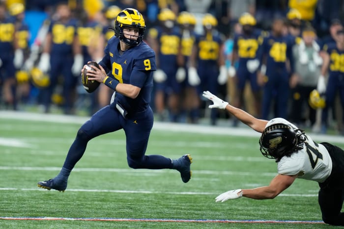 Michigan quarterback J.J. McCarthy (9) scrambles as Purdue linebacker Kieren Douglas defends during the first half of the Big Ten championship NCAA college football game, Saturday, Dec. 3, 2022, in Indianapolis.